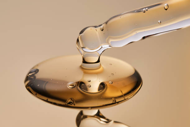 A pipette with a beautiful drop of gel-textured facial serum. High quality photo.